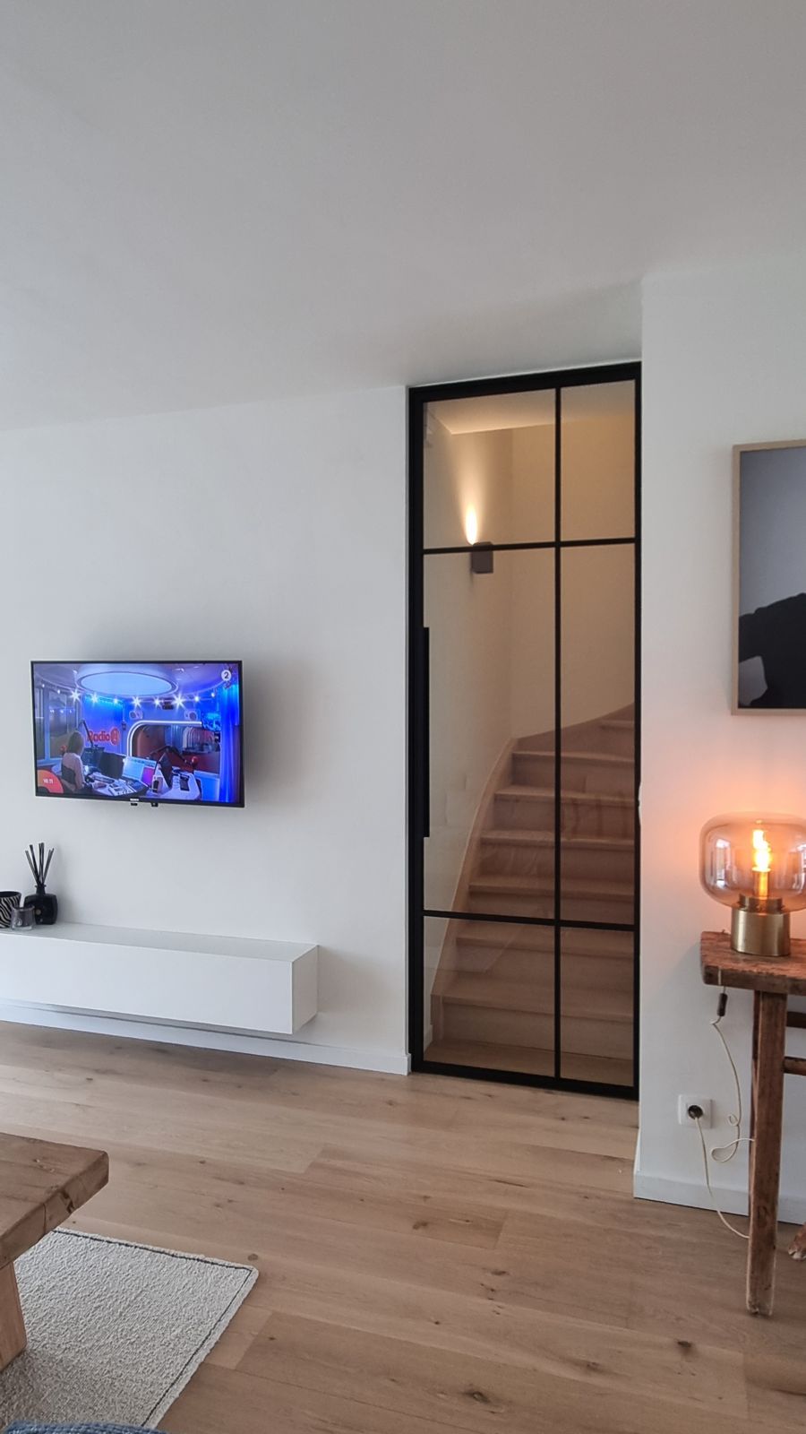Zwarte stalen scharnierdeur voor een houten trap